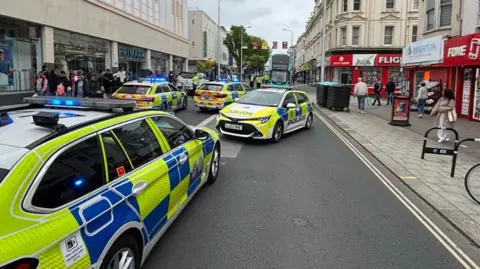 BBC Four police cars and a taped off road at Western Road in Brighton