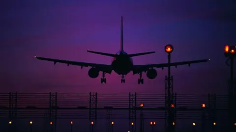 Getty Images Silhouette of a plane taking off from a fugitive seen against a deep purple sky