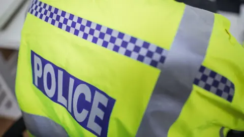 Getty Images A police officer's fluorescent uniform, with a male officer's back to the camera.