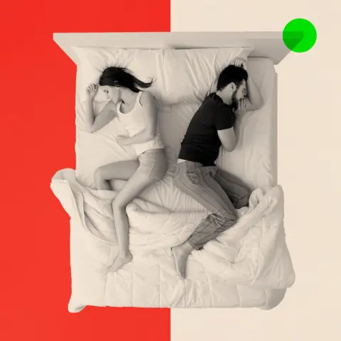 BBC A woman and a man sleeping in bed back to back, top view
