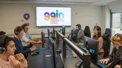 Business Surrey Six people sit at computers