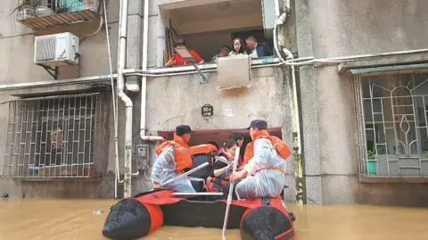 Xinhua Rescuers evacuate stranded residents on Saturday in the flood-hit city of Shaoguan, Guangdong province