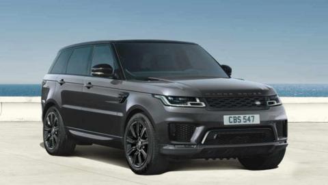 Promotional image from JLR of a dark grey Range Rover with the sea in the background
