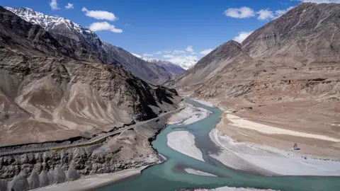 A general view of a river running through the area with the Himalaya Mountains in the background in Leh, one of the most remote areas of the Indian-administered portion of the Kashmir region, on April 13, 2025.