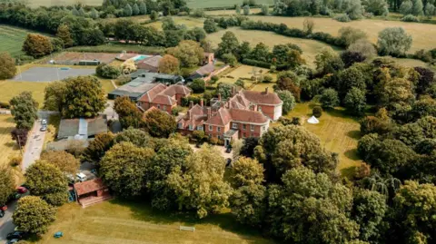 Stoke College An aerial image of Stoke College. There is a collection of brick buildings in the middle of the image, they are surrounded by trees and fields