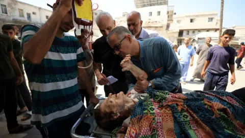 Reuters A wounded Palestinian Christian woman is brought to Al-Ahli hospital in Gaza City after what the Latin Patriarchate called a "raid" on the Church of the Holy Family (17 July 2025)
