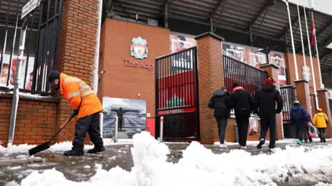 Workers clear snow outside Liverpool's Anfield Stadium