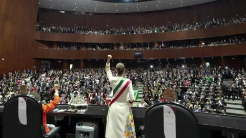 Mexico's new President Claudia Sheinbaum raises her fist as she delivers a speech during her inauguration ceremony in Congress in Mexico City, Mexico, October 1, 2024.