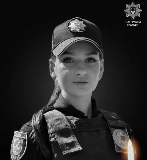 National Police of Ukraine Black and white pheadshot of Viktoria Shpylka in her police uniform. She is wearing a police cap and has her hair in a pony tail.