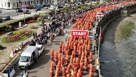 Helen's Drone Adventures A long row of dinosaurs leaving the start line seen from above.
