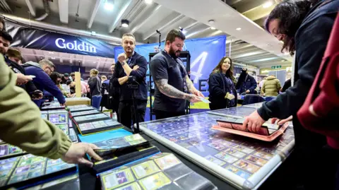 Collectors look through collectable cards at a collectors' fair.