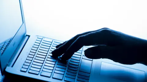 A person typing on a laptop. 