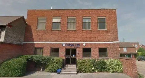 Google The red brick facade of the head office of Clays in Bungay with large windows, brown doors and concrete steps 