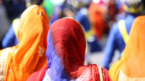 Sikh women with veils over their heads during a procession