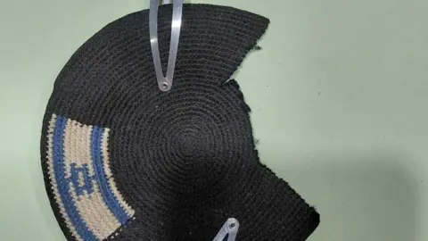 Alex Sinclair A Jewish kippah with an Israel flag on one side and the other side with a piece cut out of it