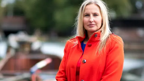 Black Country Chamber of Commerce Sarah Moorhouse pictured. She has long blonde hair and is wearing a red jacket and red and purple clothes under it. 