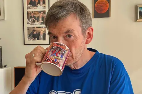 Ian Rankin drinking a cupful  of beverage  portion    looking astatine  the camera 