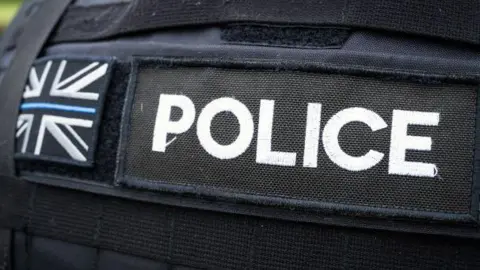 Rear view of a police jacket with the union flag depicted in white, black and blue.