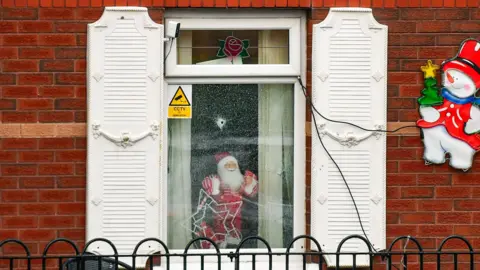 Pacemaker A house with Christmas decorations and bullet holes in the window