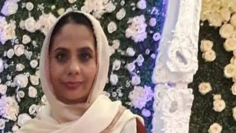 A photo of Rizwana Kousar at a social event. She is a South Asian woman wearing a white-coloured headscarf and smiling.