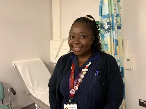 NUH A woman in a nurses uniform 