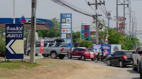 Long queues of vehicles line the road in Mae Sot, west Thailand waiting for fuel amid ongoing supply concerns. Residents in Mae Sot are rushing to buy fuel due to worries about potential shortages and price increases from the conflict in the Middle East. 