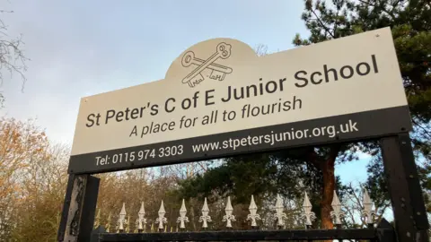 White school sign with the name in black letters