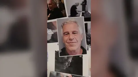Printed photos of Jeffrey Epstein overlayed on a surface. One headshot of him smiling is at the centre of the image.