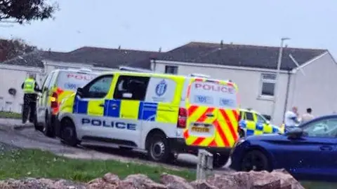 At least three police vehicles parked outside a house in Boddam