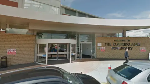 The entrance to Cumberland Infirmary which is a brick building with glass entrance. The words 'Welcome to the Cumberland Infirmary' are written on the wall in silver letters.