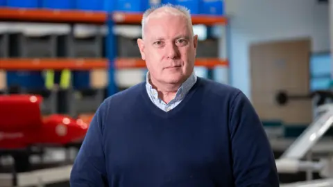 Jeremy Howitt, technical director at Snowdonia Aerospace Centre, is pictured in front of one of the drones which will be tested in Llanbedr
