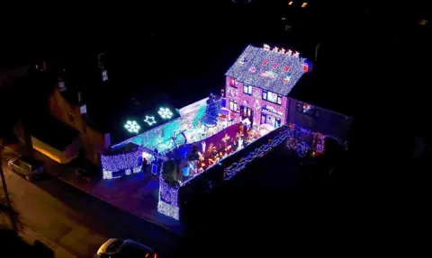 Chrissie and Ricky Fenning An aerial photo of a house and garden covered in Christmas lights.