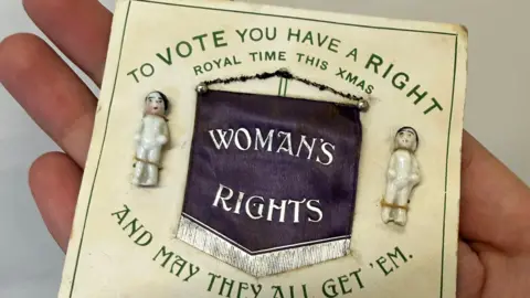A Suffragette Christmas card dating from approximately 1910. It reads 'to vote you have a right and may they all get them'. The centre of the card reads 'woman's rights', with 'royal time this xmas' above it.