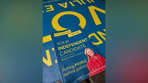 Contributed The leaflets are blue with yellow writing and have a picture of Julia Ewart on them wearing a red coat. It says "Your Independent Candidate". 