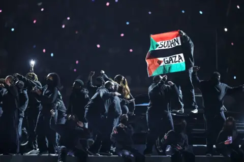 Getty Images A protestor unveiled a flag during Not Like Us