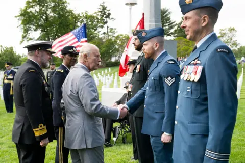 AFP via Getty Images King Charles III greets serving military personnel from the UK, Canada, Australia and New Zealand after laying a wreath at the tomb of the unknown soldier in Arlington National Cemetery in Arlington, Virginia, on April 30, 2026.
