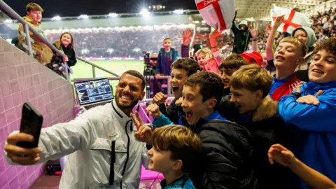 Ashton Gate Stadium Dozens of young football fans pose for the camera as a man takes a selfie during the England Under-21 match at Ashton Gate Stadium