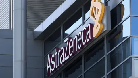 A 3D AstraZeneca sign fixed to a modern glass building.