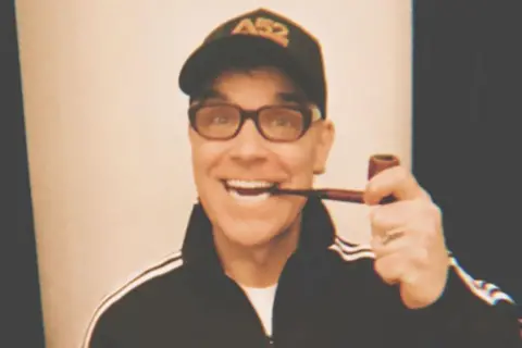 Instagram/@RobbieWilliams Robbie Williams is wearing Eric Morecambe's glasses and posing with his pipe in his mouth.