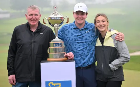 Reuters Robert MacIntyre, his father Dougie and his girlfriend Shannon Hartley