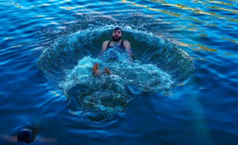 EPA-EFE/REX/Shutterstock A Kashmiri man swims in waters of the Dal Lake to cool off during hot weather, in Srinagar, the summer capital of Indian Kashmir, 22 May 2024. Kashmir is witnessing above normal temperatures as the summer season gets underway. The local meteorological department has forecasted mainly dry and hot weather conditions until 28 May in the Himalayan region. Kashmir experiences hot weather conditions, Srinagar, India - 22 May 2024