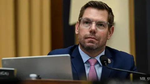Reuters U.S. Representative Eric Swalwell wears a navy suit and translucent-framed spectacles as he attends a House Judiciary Committee hearing