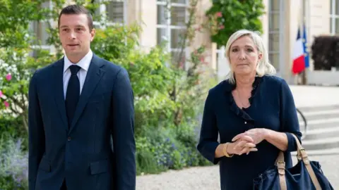 Getty Images Jordan Bardella, voorzitter van de Nationale Assemblee (Rassemblement National), links, en Marine Le Pen, leider van de National Rally