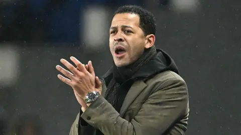 Strasbourg manager Liam Rosenior clapping in the dugout