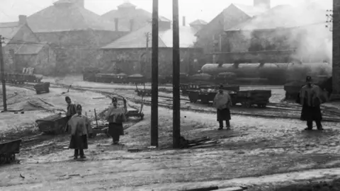 Topical Press Agency | Hulton Archive | Getty Images Police in helmets and cloaks to protect against the elements keep guard in the grounds of a colliery