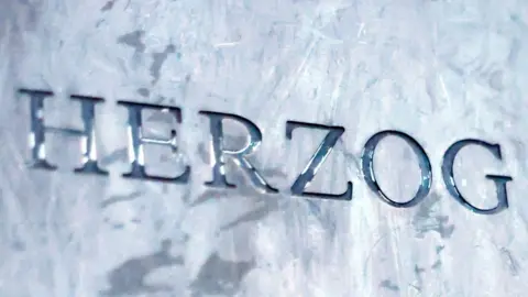 A close shot of a metal plaque saying Herzog