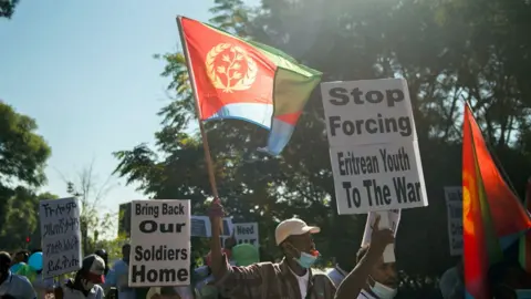 Getty Images Eritreaner som bor i Sydafrika protesterar vid Eritreas ambassad i Pretoria och kräver att eritreanska soldater drar sig tillbaka från Etiopiens Tigray-region - maj 2021