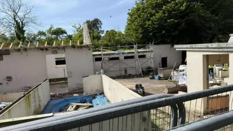 A building side with scaffolding around buildings due to be pulled down.