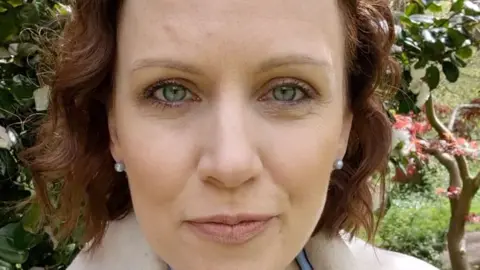 Presenter Alex Humphrey's in park standing in front of tree