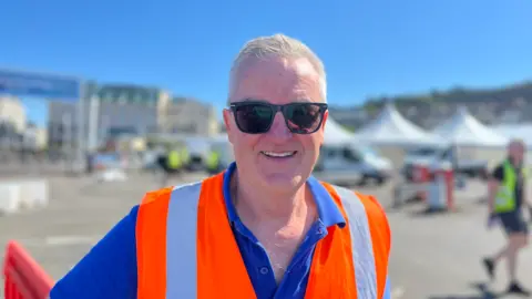 Man in orange high-viz vest over blue polo shirt